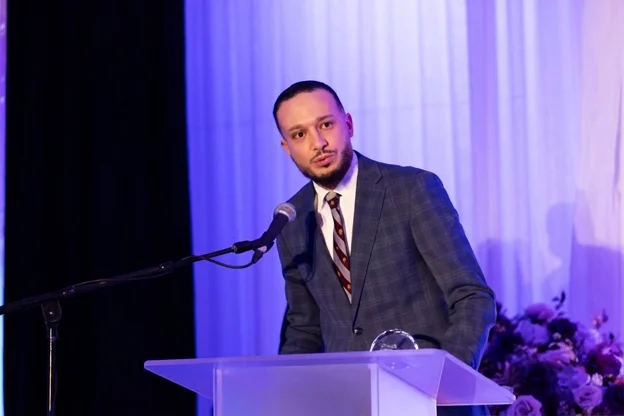 Karam El Wardi speaking at a podium